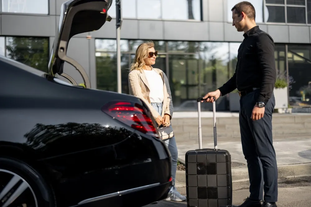 Professional chauffeur loading luggage into a luxury car for a McLean VA to DCA airport transfer